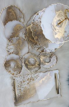 some gold and white dishes on a furnishing area with a pen in the middle