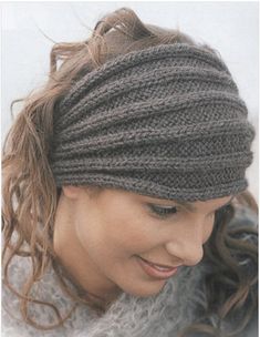 a woman wearing a knitted headband looking down at her cell phone