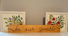 two wooden signs with flowers and the words be our guest