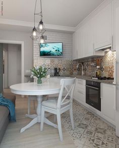 a white table and chairs in a small room with a tv mounted on the wall