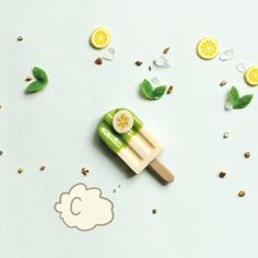 an ice cream popsicle sitting on top of a table next to lemon slices and leaves