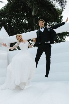 a bride and groom jumping in the air