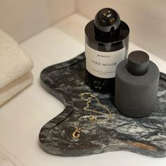 a bottle of wine sitting on top of a marble tray next to a soap dispenser