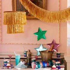 a table topped with paper stars and tinsel hanging from the ceiling