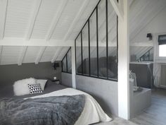 a bed sitting under a window in a bedroom