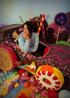 a woman laying on top of a bed covered in candy