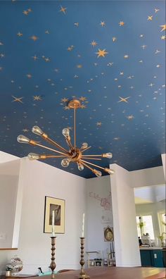 the ceiling is decorated with gold stars and chandelier lights in an otherwise white room