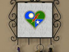 there is a key holder with two keys in it and a heart on the wall