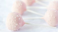 some pink cake pops with white sprinkles on them