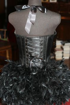 a black corset with feathers on it