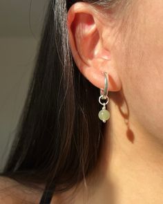 This pair of mossy-green dangle earrings will be your go-to piece. Shinny 6-7mm round nephrite, a variation of jade known for its exceptionally deep green hue, matches with minimal S925 Sterling Silver hoop earrings. ✿ Sold in a pair ✿ Material: 6-7mm /0.24-0.28in Natural Round Nephrite ✿ Finish: 15mm S925 Sterling Silver Huggie Hoops ✿ Approx. 1 inch in length and 0.6 inch in width ✿ Tarnish resistant, hypoallergenic, safe for sensitive skin Green Gemstone Dangle Hoop Earrings, Green Sterling Silver Huggie Earrings, Green Sterling Silver Hoop Earrings For May Birthstone, Dainty Green Round Hoop Earrings, Dainty Green Hoop Earrings, Green Sterling Silver Small Hoop Jewelry, Green Small Hoop Sterling Silver Jewelry, Minimalist Green Hoop Earrings With Ear Wire, Green Sterling Silver Small Hoop Earrings