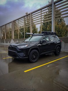 a black toyota rav parked in a parking lot