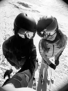 two people on skis in the snow with helmets and goggles over their eyes