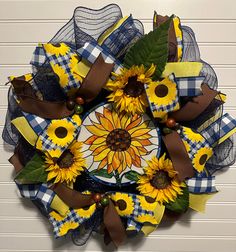 a wreath with sunflowers and plaid ribbon