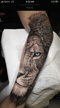 a man's arm with a lion tattoo on it and blue eyes in the center