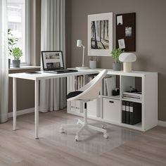 a white desk with a laptop computer on top of it next to a book shelf