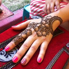 a woman's hand with henna tattoos on it