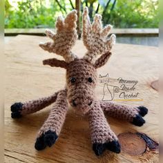 a crocheted moose sitting on top of a wooden table