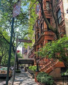 an apartment building on the corner of a street in new york city, with stairs leading up to it