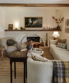 a living room filled with furniture and a fire place under a painting on the wall