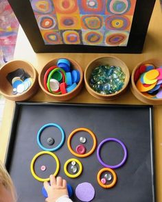 a child is playing with magnets on a tray