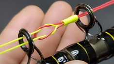 a person is holding two wires connected to an electrical device with yellow and red wires