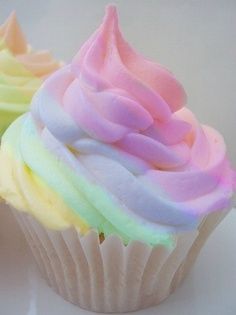 three cupcakes with different colored frosting on them are shown in close up