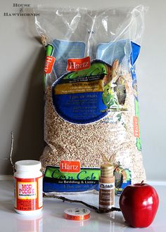 an apple and two bags of food sitting on top of a white counter next to each other