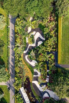 an aerial view of a park with trees, grass and walkways in the middle