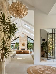 a living room with a large mirror and a plant in the corner next to it