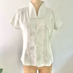 Very Classic And Sophisticated Asian Chinese Style Blouse Top W/ Mandarin Collar And Rope Button Closures. Pretty Ivory Floral Pattern With Subtle Silver Shine 100% Polyester, Unlined Very Slight Shoulder Pads (Removable) Size:Xl Tagged But Seems More Like M To L Modern Day Measurements. B:19.5” W:17” L:23” Classic Summer Blouse With Covered Buttons, Spring Wedding Button-up Blouse, Fitted Summer Tops With Covered Buttons, Fitted Blouse With Button Closure For Wedding, Fitted Wedding Blouse With Button Closure, Classic Summer Wedding Top, Elegant Summer Blouse With Back Button Closure, White Fitted Blouse With Covered Buttons, Fitted White Blouse With Covered Buttons