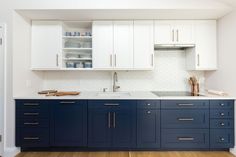 a kitchen with white cabinets and blue drawers