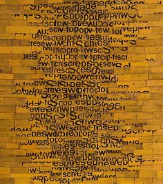 a piece of wood with words written in black and yellow on the bottom half of it