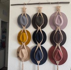 several hats are hanging on a wall with ties attached to the top and bottom of them