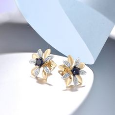 These earrings are the perfect mix of classic and contemporary. The blue sapphire center stone is surrounded by dazzling pave diamonds in a beautiful floral design . Whether you’re dressing up for a formal event or just accenting your everyday outfit, these earrings will add a touch of elegance and sophistication. Details Item Type: Fine Jewelry Earrings Metal Type: 14k Yellow Gold Earring Size: 13.0*13.5mm Main Stone: Diamond 20pcs Diamond: 0.06 ct. t.w. Side Stone: Blue Sapphire 2pcs Blue Sapp Elegant Blue Flower Earrings For Anniversary, Fine Jewelry Flower Earrings With Diamond Accents, Trendy Stud Earrings, Gold Earrings For Women, Blue Sapphire Diamond, Natural Blue Sapphire, Blue Sapphire Rings, Flower Earrings Studs, Yellow Gold Earring