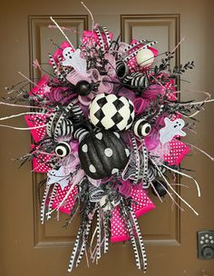 the wreath is decorated with black, white and pink decorations on it's front door