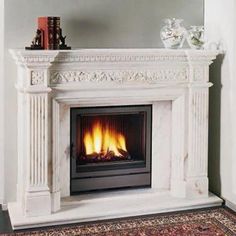 a white fireplace with a mirror above it