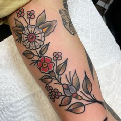 a woman's arm with flowers and butterflies on it