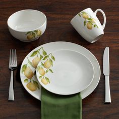 there is a plate with lemons painted on it and silverware next to it