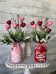 two valentine's day vases with flowers and hearts on them