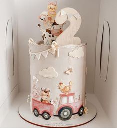 a birthday cake decorated with animals and cars