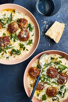 two bowls of pasta with meatballs and spinach garnished with parmesan cheese