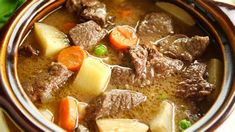 a close up of a bowl of food with meat and vegetables in it on a table