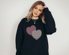 Our pink leopard hearts sweatshirt is a cute sweatshirt for Valentines Day and any time of year! It's the perfect heart pullover to throw on for a chilly day or as a cute Valentines Day sweatshirt.  Featuring two pink leopard print hearts on a comfortable fit, crewneck (unisex sized) sweater; this sweatshirt fits like a well-loved favorite. Soft cotton and quality print make this a sweatshirt that you will fall in love with it over and over again.  More on comfort and fit: ------------------- Ideal for any situation, our unisex heavy blend crewneck sweatshirt is pure comfort. There are no itchy side seams on these sweaters! These garments are made from polyester and cotton. This combination helps designs come out looking fresh and beautiful. The collar is ribbed knit, so it retains its sha Oversized Crew Neck Sweater With Heart Print, Trendy Long Sleeve Sweatshirt With Heart Print, Trendy Cotton Sweater With Heart Print, Winter Long Sleeve Sweatshirt With Heart Print, Winter Heart Print Long Sleeve Sweatshirt, Long Sleeve Heart Print Sweatshirt For Winter, Pink Long Sleeve Sweatshirt With Heart Graphic, Winter Crew Neck Sweatshirt With Heart Print, Winter Heart Print Crew Neck Sweatshirt