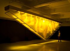 a person standing in an empty room with yellow lights