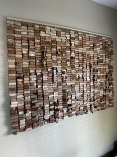 a wall hanging made out of wooden planks on the side of a white wall