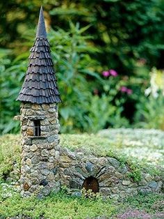 a miniature house made out of rocks and grass