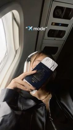 a woman reading a book while sitting on an airplane