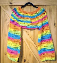 a multicolored sweater hanging on a wooden wall