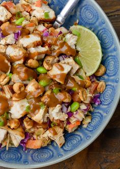 a blue bowl filled with chicken and vegetables